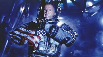Bruce Willis in a spacesuit holding an American flag.